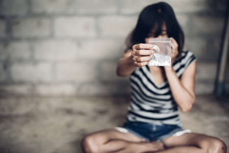 Drug addict young woman with syringe in action, Drug abuse concept.