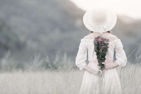 Woman holding flowers in the meadow Vintage styleの写真素材