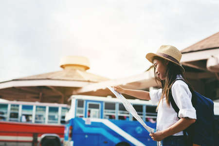 Happy female tourist on map  to Bus station vacation. Travel concept.のeditorial素材