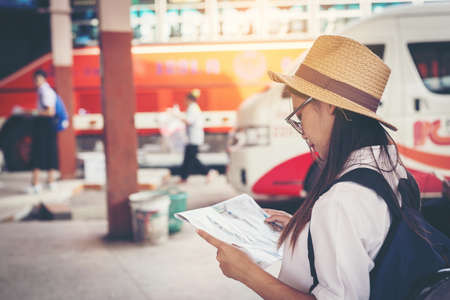 Happy female tourist on map  to Bus station vacation.Travel concept.のeditorial素材