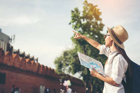 happy female tourist  searchingroad to travel on atlas in city during vacation.,Travel concept.の写真素材
