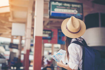 Happy female tourist on map  to bus station vacation. Travel concept.のeditorial素材