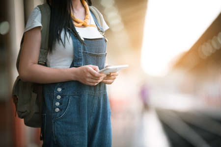 Happy woman tourists in the train station on a mobile tablet.Travel concept.の写真素材