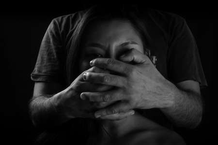 Victim of domestic violence, Human trafficking concept, End to violence against women,Scared woman with man's hand covering her mouth,の写真素材