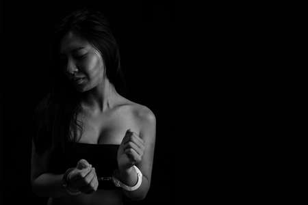 The girl was handcuffed on a black background, Human trafficking, End to violence against women,Stop abusing violence.の写真素材