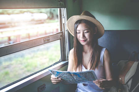 Travelers young woman with backpack looking hold a map at the train station. Tourism day concept.の写真素材