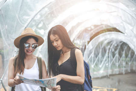 Travelers young woman with backpack looking hold a map at the train stationの写真素材