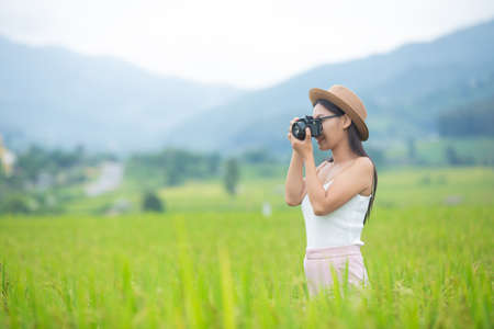 Young woman photograph standing in green grassland.の写真素材