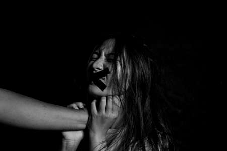Preventing violence against women, All talk and no action. Victim of domestic violence, Human trafficking concept, End to violence against women,Scared woman with man's hand covering her head, Sexual violence against womenの写真素材