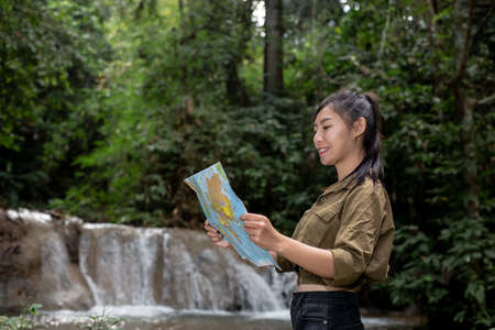 The lifted girl smiled happily in the hand with a backpack map.の写真素材