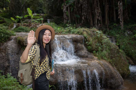 Female tourists are happy and refreshed at the waterfall.の写真素材