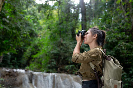 Female hikers take pictures of themselves with beautiful waterfalls. Relax after hikingの写真素材