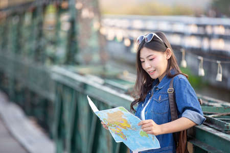 Female tourists on hand have a happy travel map.の写真素材
