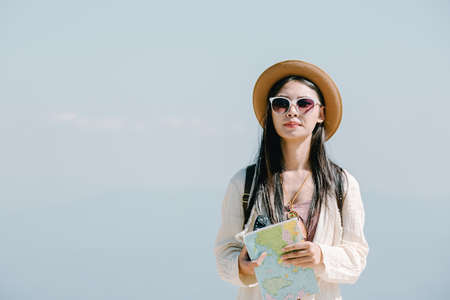 Female tourists on hand have a happy travel map.