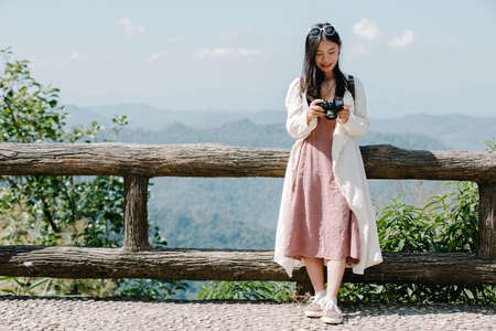 Female tourists who are taking photos of the atmosphere and smile happily.の写真素材