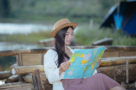 Female tourists on hand have a happy travel map.の写真素材