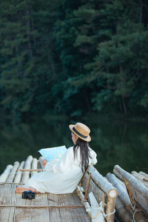 Female tourists on hand have a happy travel map.の写真素材