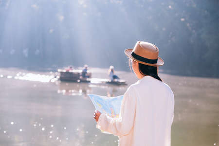 Female tourists on hand have a happy travel map.