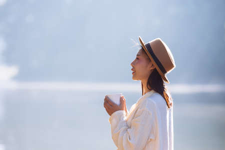 Female tourists are drinking coffee in the morning on the river.の写真素材