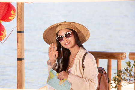 Female tourists on hand have a happy travel map.の写真素材