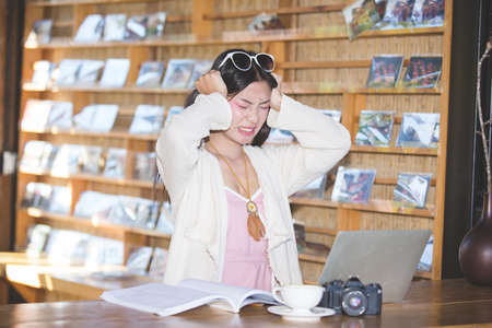 Women who are stressed about working in a coffee shopの写真素材