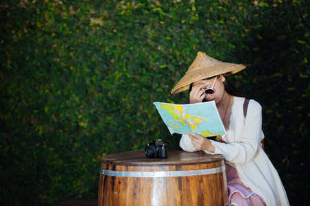 Female tourists on hand have a happy travel map.