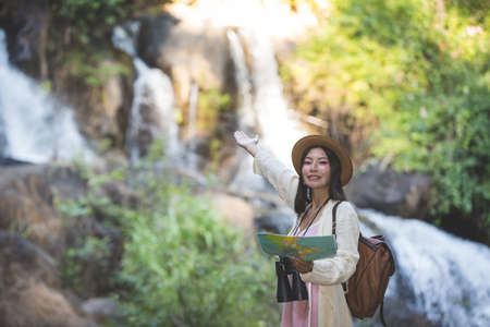 Female tourists on hand have a happy travel map.の写真素材