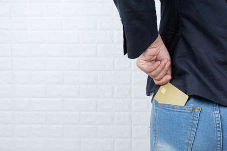 Business woman holding a separate cash card, white brick wall Made gestures with sign language.の写真素材
