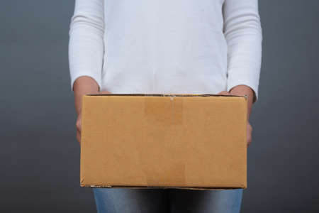Woman holding a brown post box Made gestures with sign language.の写真素材