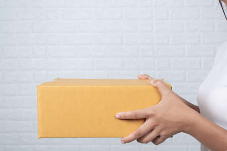Woman holding a brown post box Made gestures with sign language.の写真素材