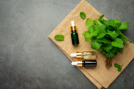 Essential oil of peppermint in bottle with fresh green peppermintの写真素材