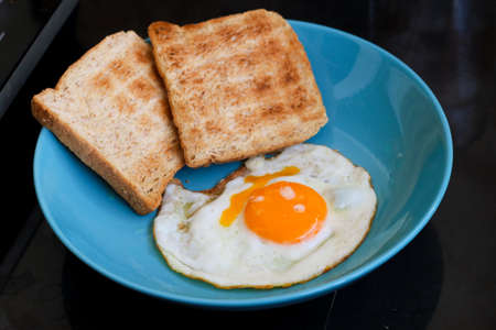 Fried egg and bread on dishの写真素材