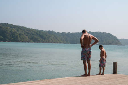 father and son look in to the seaの写真素材