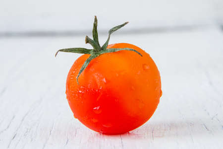 Fresh red tomato on white wooden table