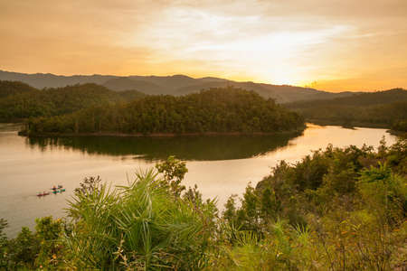 man kayaking on Lake at sunset, Kanchanaburi, Thailandの写真素材
