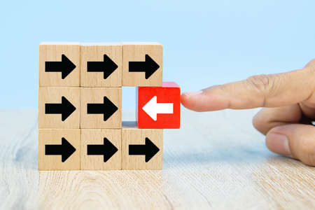 Businessman hand choose red wooden toy blog with arrow icons concept of business for Change leader to growth and success.の写真素材