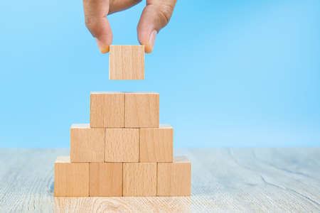 Hand choose cube shape wooden block toy stacked without graphics for Business design concept and activity  for child foundation practice skills.の写真素材