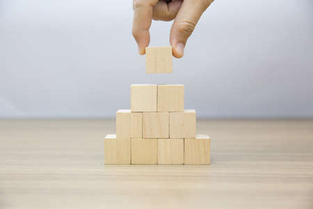 Hand choose wooden cube stacked without graphics for Business design concept and activity  for child foundation practice skills.の写真素材