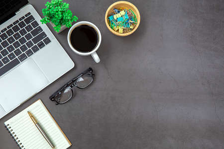 Top view desk,Modern office desk Workspace with laptop computer, coffee cup, glasses,notebook and...