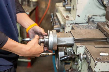 Technician work with lathe machine Industrial metal processing.