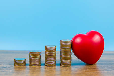 Red heart with shaped graph coin stacked and concepts a physical examination and health insurance.の写真素材