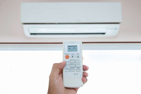 Close up hand and remote control air condition.の写真素材
