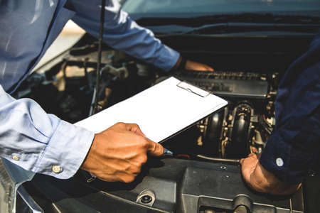 Auto mechanic using checklist for car engine systems after fixed. concepts of car insurance support and services.の素材 [FY310147640320]