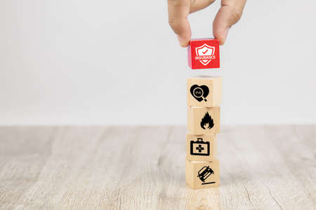 Hand choose a cube wooden toy blocks with protect insurance icon for safety family and services insurance concepts.の写真素材