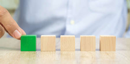Close-up hand chooseing cube wooden block toy stacked without graphics for Business design concept and build activity for children play create and practices foundation stage.の写真素材