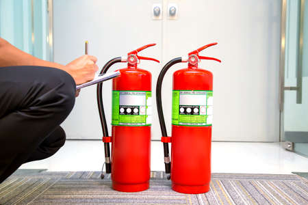 Fire fighter are checking fire extinguishers tank in the building concepts of fire prevention...