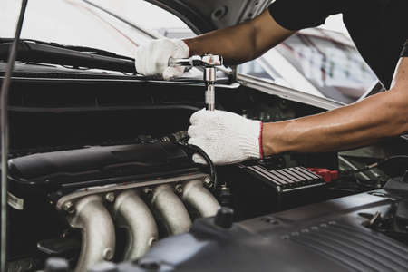 Close-up hand of auto mechanic using wrench to repair a car engine. concepts of car care fix repair...