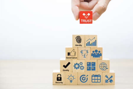 Close-up hand choose trust icon on wooden block for business à¸¢lanning and administration concept.の写真素材