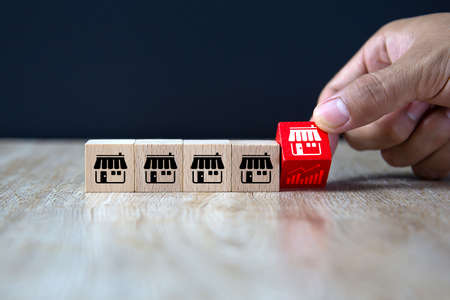 Franchise business,Businessman hand choose wooden blog with franchise marketing icons store.の写真素材