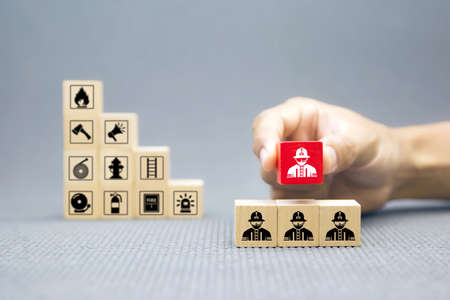 Hand choose wooden block with Firefighter icon for fire and safety Concept.の写真素材